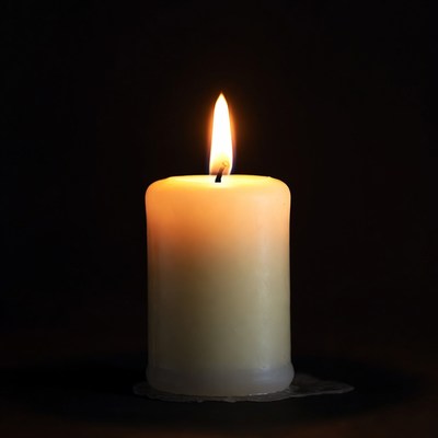 Burning Candle on Black Background