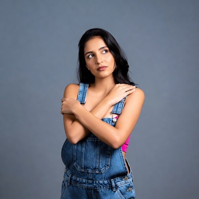 Woman in blue overalls arms crossed