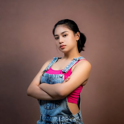 Asian woman in denim overalls and pink top