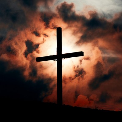Silhouette cross in dramatic sunset clouds
