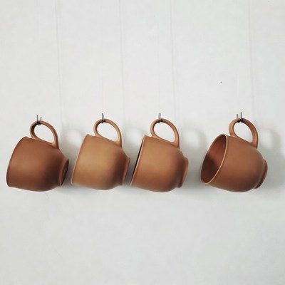Four Terracotta Mugs Hanging on Wall