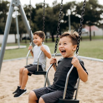 Boys swinging on playground swings