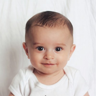 Smiling Baby Boy in White Onesie