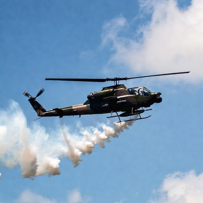Military helicopter flying with smoke trail
