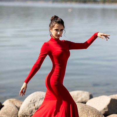 Woman dancing in red dress by lake