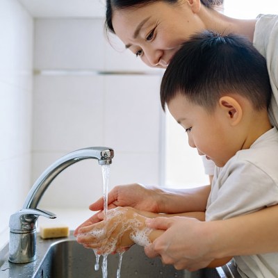 Asian mother teaching boy handwashing