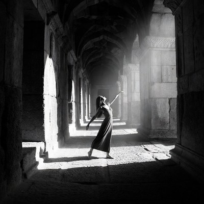 Woman dancing in ancient stone corridor