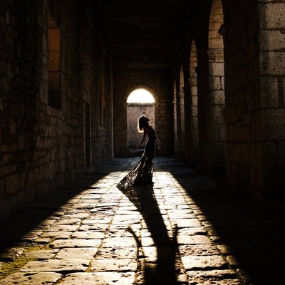 Woman in black dress in stone cloister
