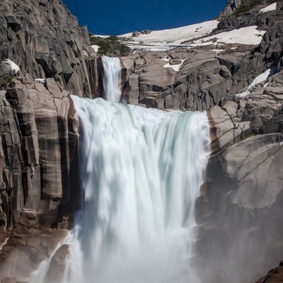 Waterfall cascading rocky mountains snow