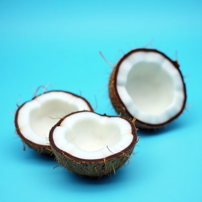 Three halved coconuts on blue background