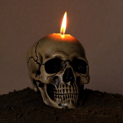 Skull Candle Burning on Dirt