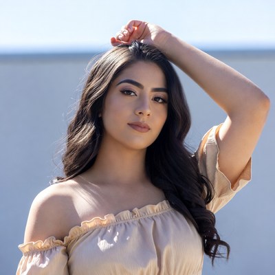 Latina woman posing with hand on head