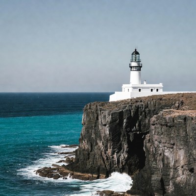 White lighthouse on ocean cliff