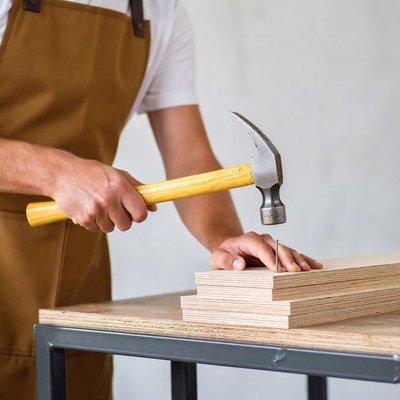 Man hammering nail into wood