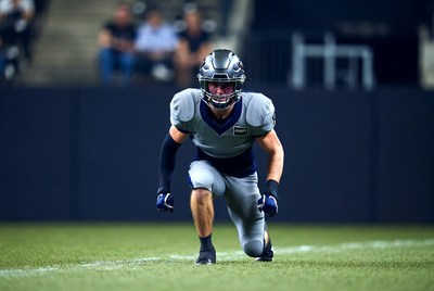 Football player in gray uniform crouching
