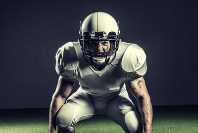 Football player in white uniform crouching