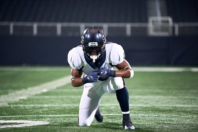NFL player kneeling on football field