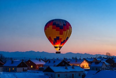 Colorful hot air balloon over snowy village