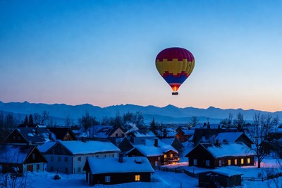 Hot air balloon over snowy village