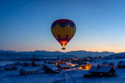 Hot air balloon over snowy village