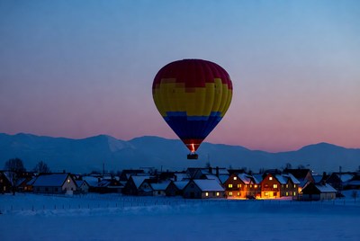 Hot air balloon over snowy village
