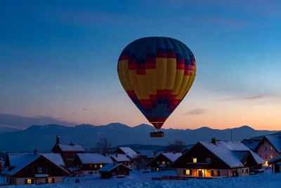 Hot air balloon over snowy village