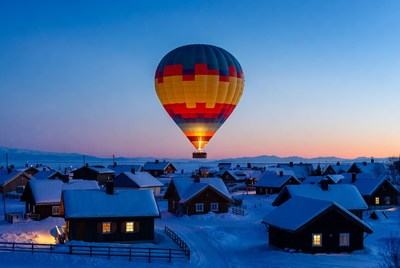 Hot air balloon over snowy village