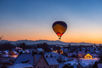 Hot air balloon over snowy village