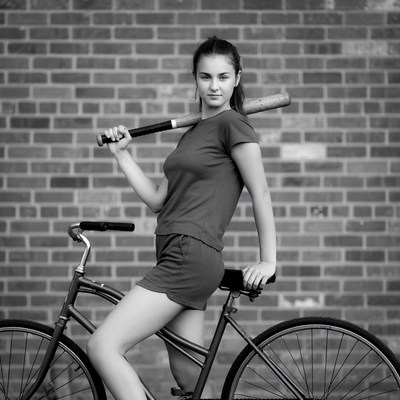 Woman posing with bat and bicycle