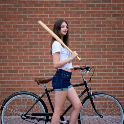 Teen girl with baseball bat and bicycle