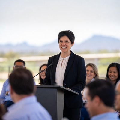 Woman speaking at podium with audience
