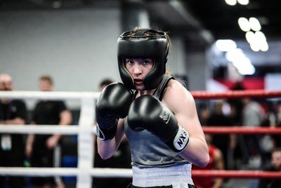Female boxer in ring with gloves