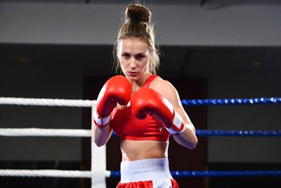 Woman boxer in red gloves ring