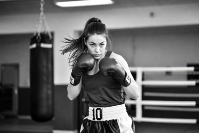 Woman boxer with gloves in gym