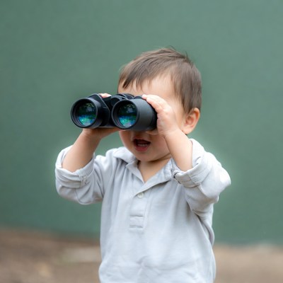 Toddler boy using binoculars