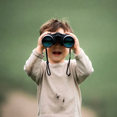 Boy using binoculars outdoors