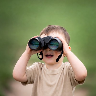 Boy using binoculars outdoors