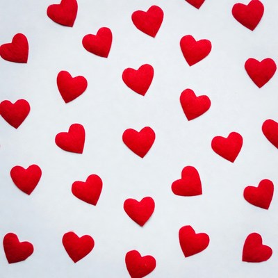 Red hearts scattered on white background