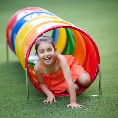 Girl crawling through colorful tunnel