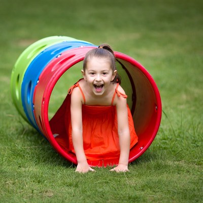 Girl crawling through colorful tunnel