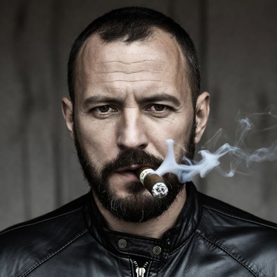 Man smoking cigar in leather jacket