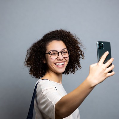 Smiling woman taking selfie with iPhone