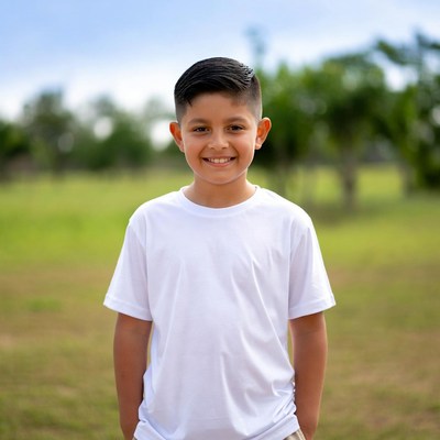 Smiling Latino boy in white t-shirt outdoors