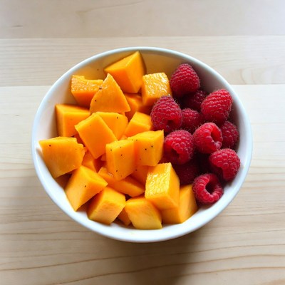 Mango and Raspberries in White Bowl