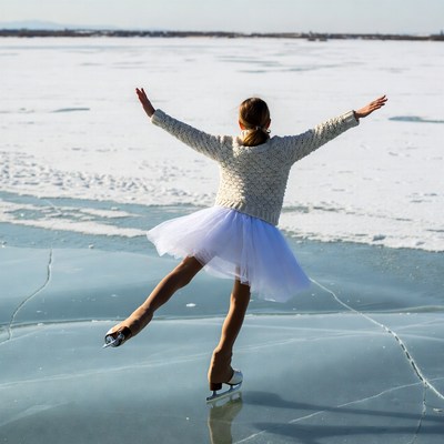 Girl ice skating on frozen lake