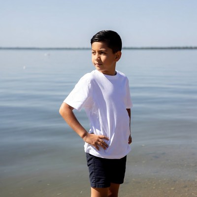 Young boy standing by lake