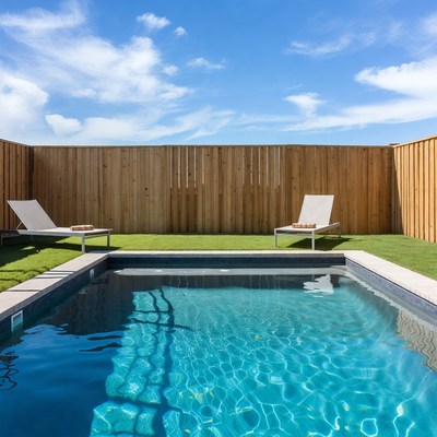 Small backyard pool with lounge chairs