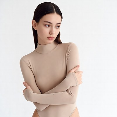 Woman in beige bodysuit arms crossed