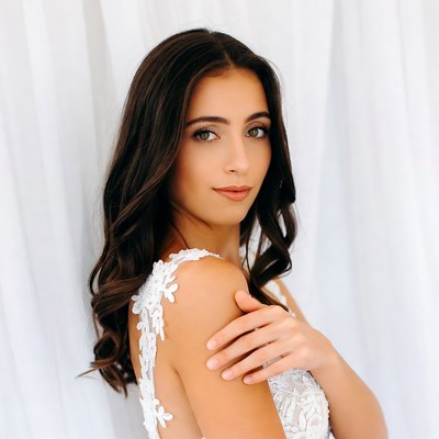Bride in lace dress against white backdrop