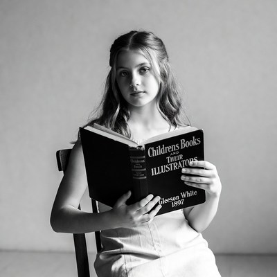 Girl reading Children's Illustrators book